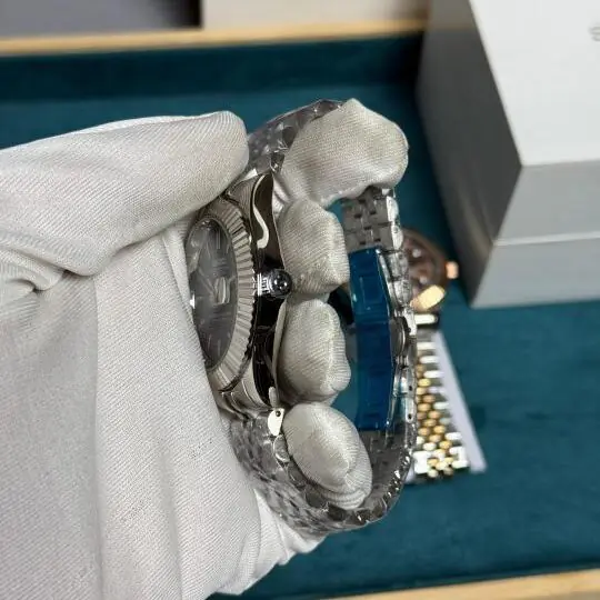 Se1ko green sunburst dial watch with fluted bezel and silver jubilee bracelet displayed on white gloved hand in watch box