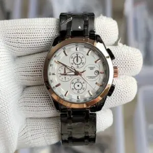 T1ssot 1853 chronograph automatic watch with white dial, rose gold tachymeter bezel and black PVD steel bracelet held on white gloved hand