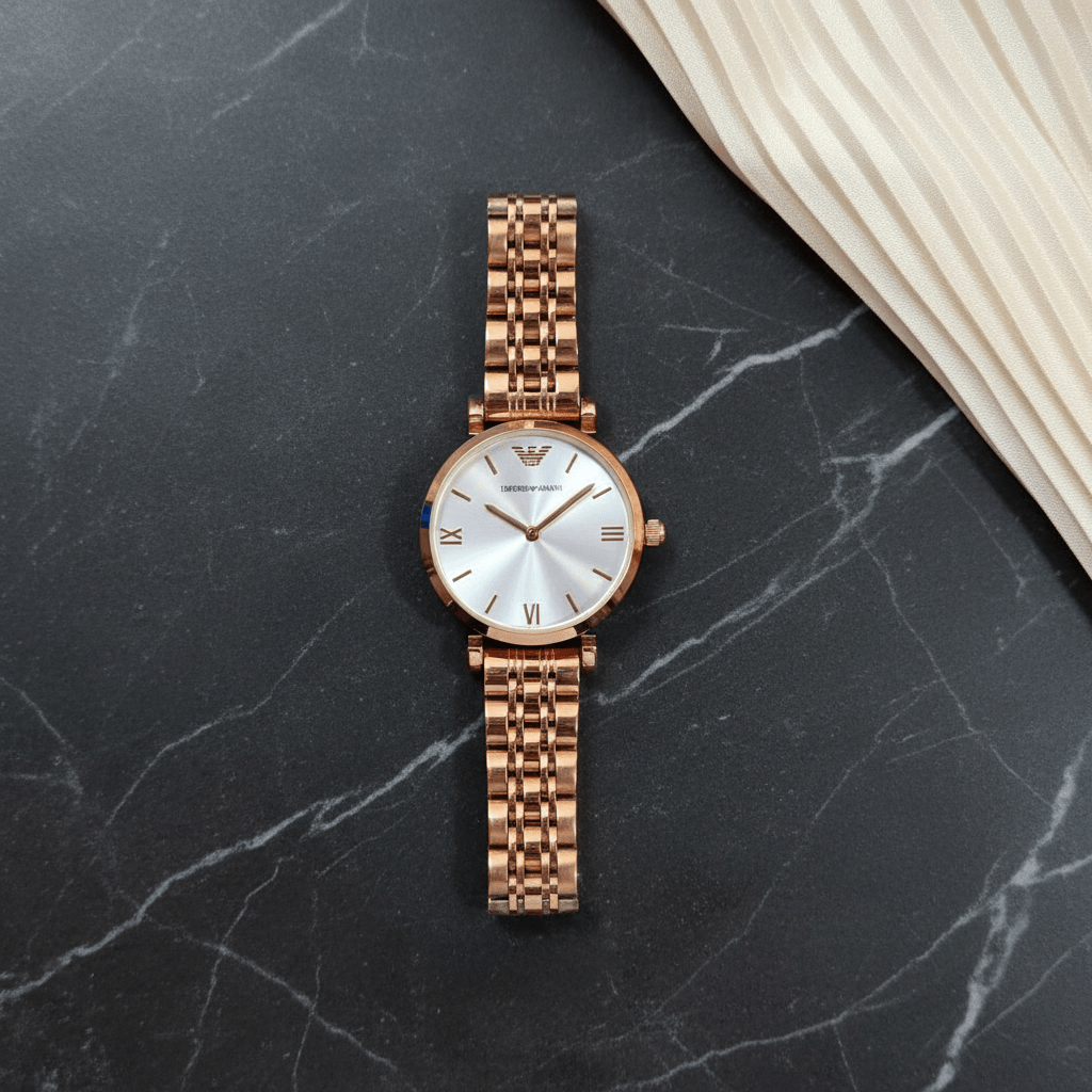 Emporio Armani women's rose gold-tone stainless steel bracelet watch with silver sunray dial and Roman numeral markers worn on wrist