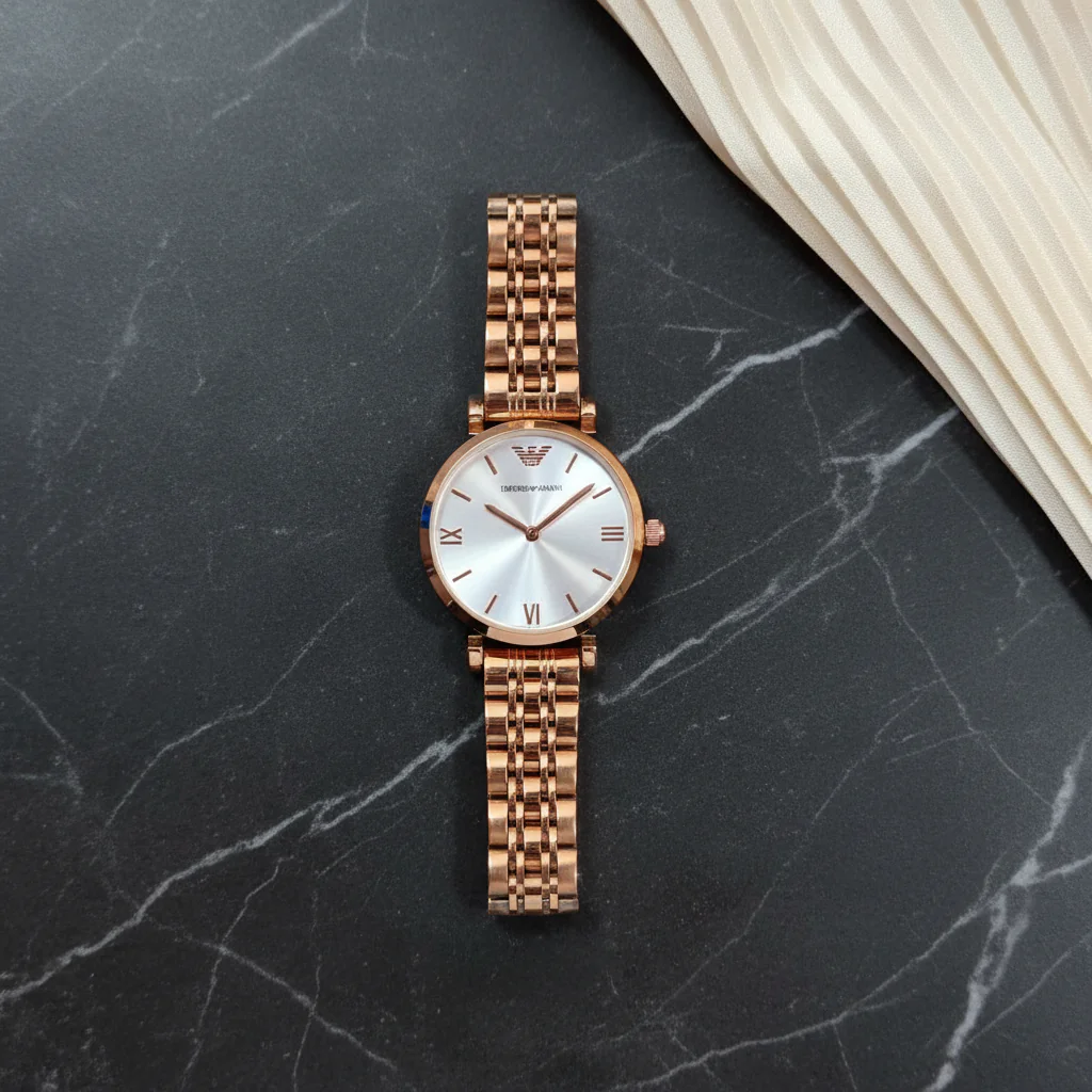 Emporio Armani women's rose gold-tone stainless steel bracelet watch with silver sunray dial and Roman numeral markers worn on wrist