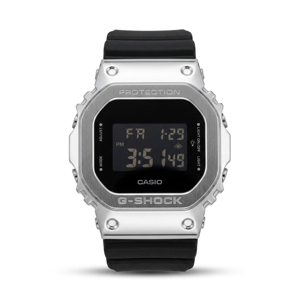 Casio G-Shock GM-5600 digital watch with brushed silver stainless steel metal bezel, black LCD display showing day and time, and black resin strap on white background